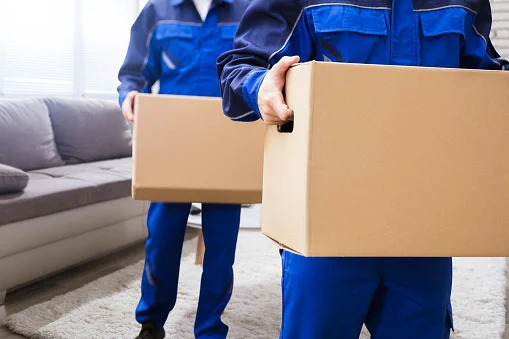 Tupelo Movers In Blue Uniforms Carrying Boxes In A House Commercial And Residential Long Distance Movers Tupelo MS - Getting ready for your long-distance move? Choose House To House Moving for seamless residential and commercial long-distance moving services in Tupelo, MS.